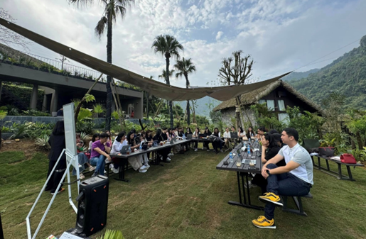 A group of people sitting at tables outside

Description automatically generated